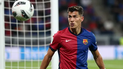 A tight action crop of an anonymous FC Basel player in his mid-20s, with a determined expression, in a floodlit stadium...