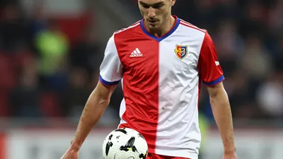 A photorealistic image of an anonymous 20-year-old winger of FC Basel, wearing a red and white jersey made of smooth...