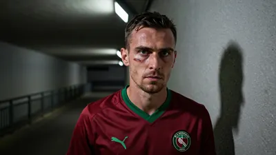 A close-up of a rugged, 35-year-old midfielder with a weathered face and a distinctive scar above his left eyebrow...
