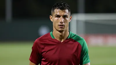 Mid-shot of a muscular early-30s male player, head-and-shoulders, intense expression, eyes sharp, short dark hair, slight...