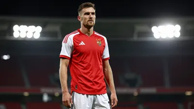 A photorealistic image of an anonymous FC Basel player in a red jersey with white sleeves and white shorts, with a black...