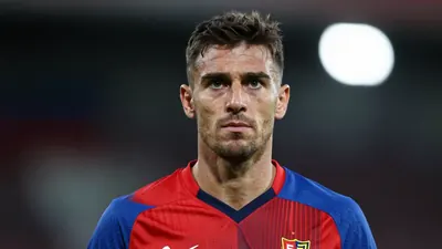 A 30-year-old FC Basel coach with a strong build, wearing a red and blue kit