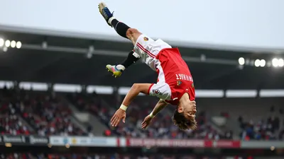A photorealistic image of a young, anonymous FC Basel player in a red jersey with white sleeves and white shorts, with a...