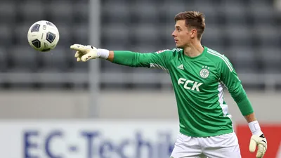 A photorealistic image of an anonymous, 25-year-old, male, FCK goalkeeper, wearing a green jersey with white sleeves, and...
