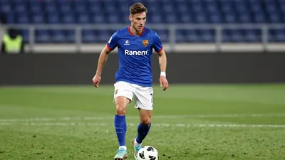 A tight action crop of an anonymous FC Basel player in a blue jersey with white shorts and blue socks, looking determined...